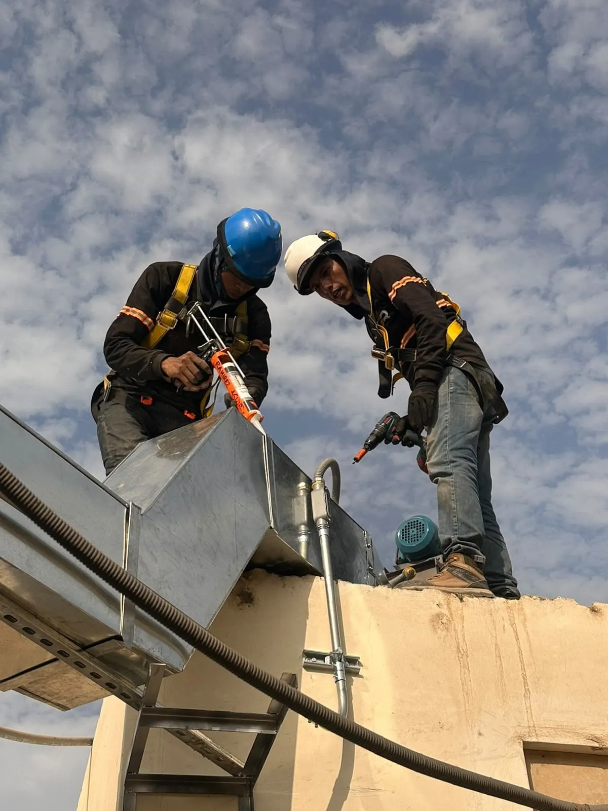 Técnicos de Gerar realizando mantenimiento de ductos en techo industrial