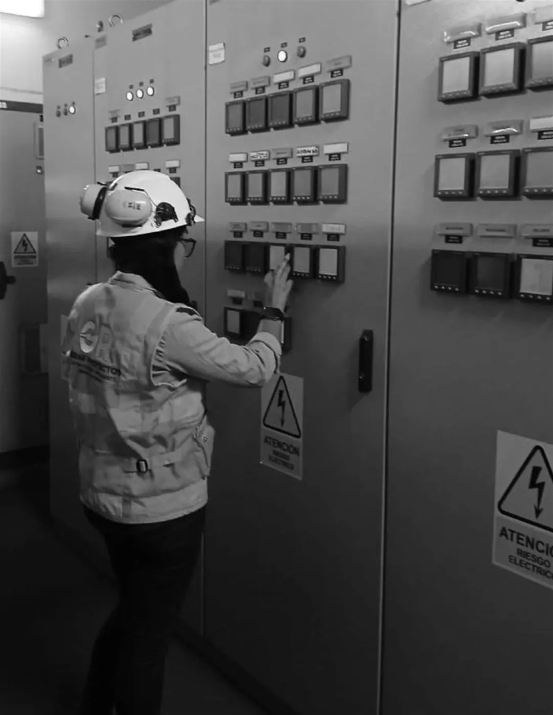 Técnica operando un tablero eléctrico de planta